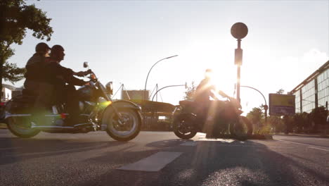 Siluetas-De-Motos-Pesadas-Cruzando-Una-Gran-Calle-Al-Atardecer,-Iluminación-Frontal