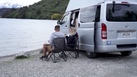 Junges-Paar-Steigt-Aus-Seinem-Wohnmobil,-Um-Am-Lake-Wakatipu,-Queenstown,-Neuseeland,-Zu-Mittag-Zu-Essen