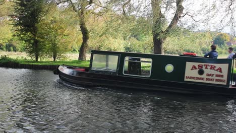 Group-of-people-having-a-day-out-on-a-narrow-boat-navigating-the-River-Wey-at-Guildford-in-Surrey,-England