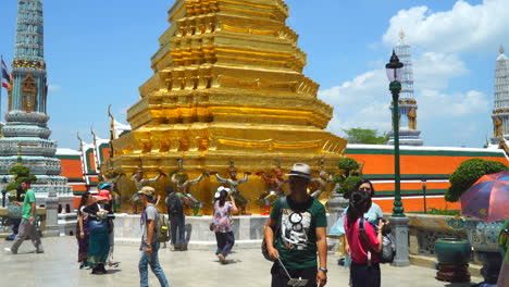 Bangkok,-Tailandia---Alrededor-De-Lapso-De-Tiempo,-Tiro-Panorámico-De-Jardines-Abarrotados-En-El-Templo-Wat-Phra-Kaew-De-Buda-Esmeralda-En-Bangkok,-Mucha-Gente,-Situación-De-Luz-Diurna-Soleada-En-El-Cielo-Azul