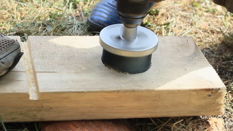 La-Persona-Está-Perforando-Un-Agujero-En-Un-Tablón-De-Madera-Con-Una-Sierra-Eléctrica