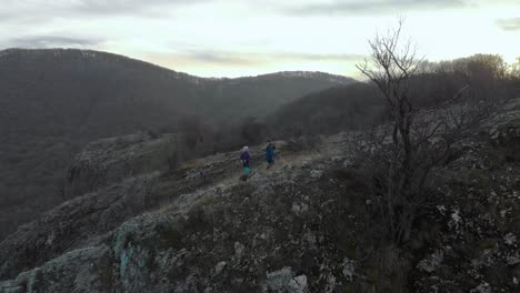 Children-play-on-edge-of-cliff---aerial-tracking-shot