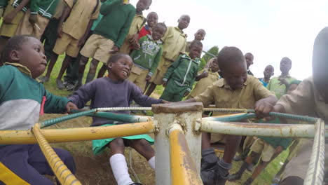 Niños-Africanos-Girando-En-Una-Rotonda-De-Juegos,-Tiro-De-Punto-De-Vista-Gopro