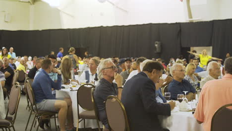 People-sitting-at-their-tables-in-a-crowded-convention-centre