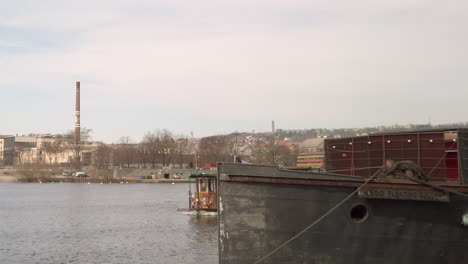 Un-Antiguo-Ferry-En-El-Río-Vltava-Emerge-A-La-Vista-Desde-La-Vuelta-De-Una-Esquina-En-Praga,-República-Checa