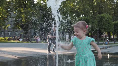 Una-Niña-Pequeña-Juega-Con-Una-Fuente-De-Agua-En-El-Centro-De-Vilnius,-La-Capital-De-Lituania