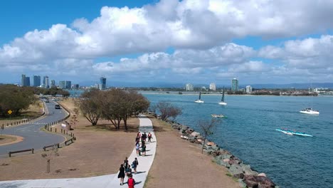 High-view-of-a-group-of-children-and-adults-walking-along-a-path-near-the-ocean-to-go-snorkelling