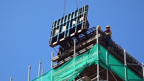 Construction-workers-working-at-height-installing-reinforcement-bar-and-form-work-at-the-construction-site