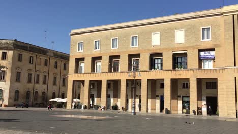 Panning-view-of-town-square-Piazza-Sant-Oronzo-in-Lecce,-Italy-with-people-walking-around