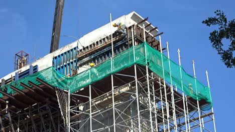 Construction-workers-working-at-height-installing-reinforcement-bar-and-form-work-at-the-construction-site