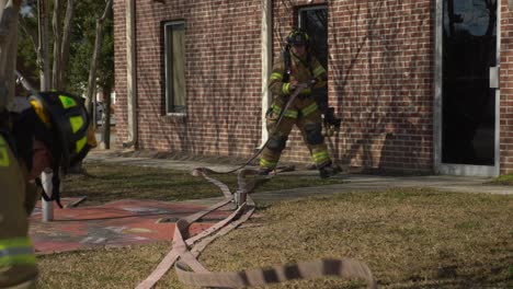 Los-Bomberos-Tiran-De-Una-Manguera-Contra-Incendios-A-Un-Edificio-Para-Prepararse-Para-Combatir-Un-Incendio