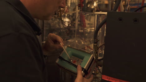 Technician-working-in-the-lab-Using-the-remote-control-in-experimenting-with-the-reactor