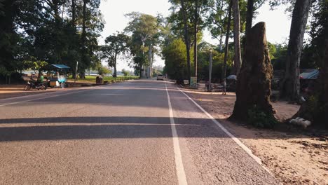 Stabilized-Shot-of-Driving-Through-Angkor-Wat-With-the-Sun-Shining-Through-the-Trees-B