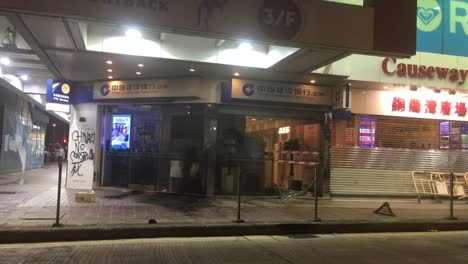 Gente-Caminando-Frente-Al-Escaparate-Destruido-De-Un-Banco-En-Causeway-Bay,-Hong-Kong