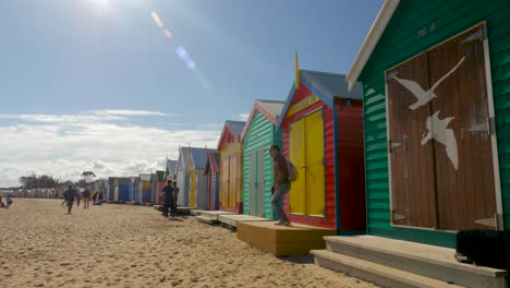 Tourists-walking-and-taking-photo-at-Brighton-Bathing-Boxes,-Melbourne,-Australia