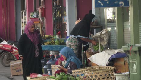 Asiatische-Frauen-Am-Straßenrand-Reden-Miteinander-Und-Tauschen-Lebensmittel