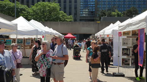 Old-couple-talking-to-each-other-and-looking-for-buying-stuffs-in-Toronto-art-fair,Canada