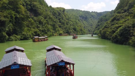 Zhangjiajie,-China---Agosto-De-2019:-Barcos-De-Madera-Tradicionales-Que-Navegan-En-Las-Aguas-De-Un-Pequeño-Lago-Estrecho-Entre-Acantilados-Rocosos-Altos-Y-Altos-Del-Majestuoso-Gran-Cañón-En-El-Parque-Nacional-De-Zhangjiajie