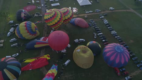 Aerial-View-of-a-Sunrise-Hot-Air-Balloons-Taking-Off-at-a-Balloon-Festival-on-a-Clear-Summer-Morning