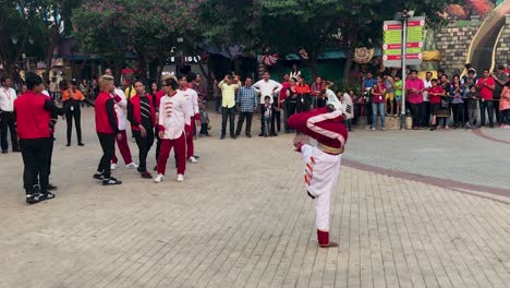 Joven-Asiático-Haciendo-Streetdance-breakdance-En-Público-Mientras-Otros-Lo-Animan-En-El-Parque-Temático-De-Diversiones-Adlabas-Imagica-En-India