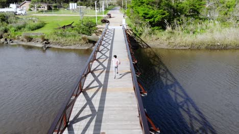 Man-running-across-a-bridge-over-the-stream-on-a-sunny-day