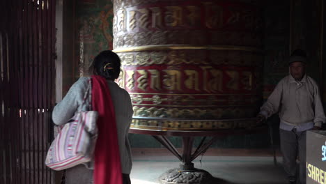 Kathmandu,-Nepal---November-16,-2019:-People-walking-around-a-large-prayer-wheel-and-making-it-spin-in-the-Bhouddha-in-Kathmandu