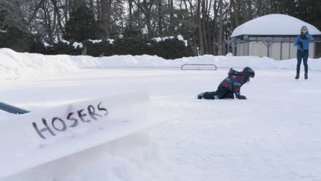 Süßer-Kleiner-Junge-Stürzt-Beim-Schlittschuhlaufen-Auf-Einer-Eisbahn-Im-Freien