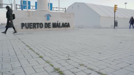 Menschen,-Die-Morgens-Am-Eingang-Des-Hafens-Von-Malaga-In-Spanien-Vorbeikommen---Dolly-Shot