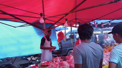 Joven-Vendiendo-Aves-Halal-En-El-Mercado-De-Alimentos-Al-Aire-Libre-Por-La-Noche