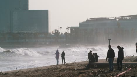 60fps:-Riesige-Wellen-Krachen-Nach-Einem-Verheerenden-Sturm-Am-Strand-Von-Barcelona,-Menschen-Machen-Fotos-–-Gezoomte-Aufnahme