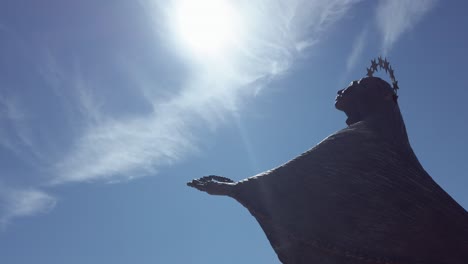 Statue-of-Virgin-Mary-facing-sun-at-Christ-the-King-Sanctuary-in-Almada,-Portugal