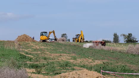 Gelber-Traktor-Und-Bagger-Arbeiten-An-Einem-Neuen-Haus,-Das-Von-Einer-Bauträgerfirma-Eingebaut-Wird