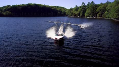 Blonde-Girl-Waterskiing,-Wide-Aerial-Drone-Tracking-Dolly-Out