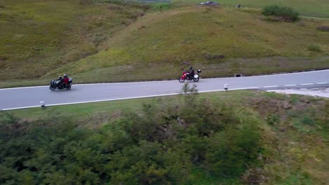 Winding-road-in-the-Dolomite-mountain-range-northern-Italy-with-motorcycles-and-cars-going-in-both-directions,-Aerial-drone-tracking-left-shot