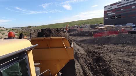 Toma-De-Cámara-De-Acción-De-Un-Camión-Volquete-Marcha-Atrás-Listo-Para-Volcar-La-Tierra-En-Un-Gran-Sitio-De-Construcción