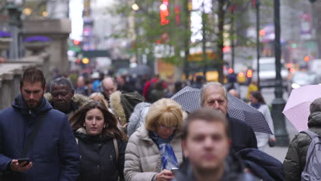 Pedestrians-walking-along-the-sidewalk-of-42nd-street-next-to-Bryant-Park-in-New-York-City