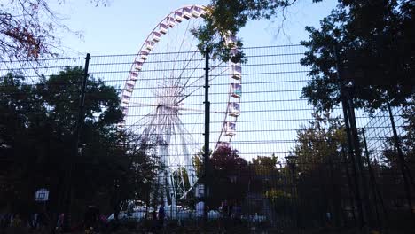 The-famous-Budapest-Eye-Ferris-Wheel-in-Hungary-in-moving-shot-behind-the-fence-is-dusk