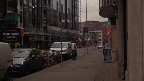 Ein-Bewölkter-Tag-In-Der-Stadt-Neben-Einer-Baustelle-Mit-Fahrzeugen-Und-Fußgängern