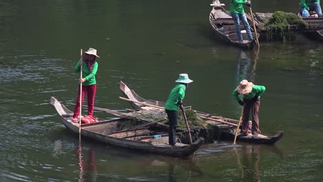 Primer-Plano-De-Damas-Asiáticas-En-Botes-Limpiando-El-Foso-Alrededor-De-Angkor-Wat-En-Camboya