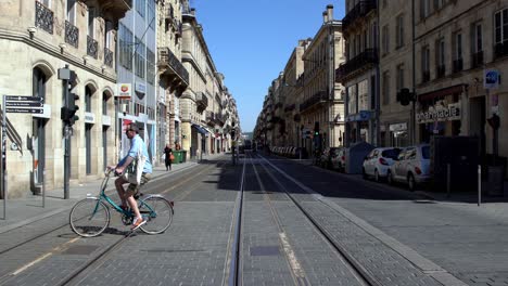 Cours-d'Alsace-et-Lorrain-street-during-the-COVID-19-pandemic-with-people-crossing-by-foot-and-on-bicycle,-handheld-shot