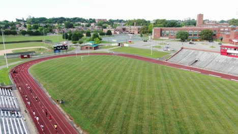 Studentensportler-Sozial-Distanziert-Beim-Training,-Sportunterricht-Auf-Der-Laufbahn-Einer-Universitätsschule,-Luftaufnahme