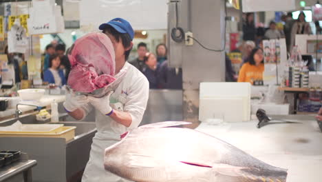 Un-Cortador-De-Pescado-Macho-Que-Muestra-Una-Cabeza-Gigante-De-Corte-Limpio-De-Atún-Rojo-A-La-Audiencia-En-El-Mercado-De-Pescado-De-Toretore-Ichiba-En-El-Mercado-De-Pescado-De-Toretore-Ichiba-En-Wakayama,-Japón---Tiro-Medio