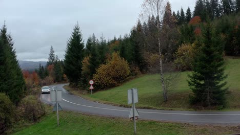 Cars-driving-across-Romanian-forest-on-autumn-cloudy-day