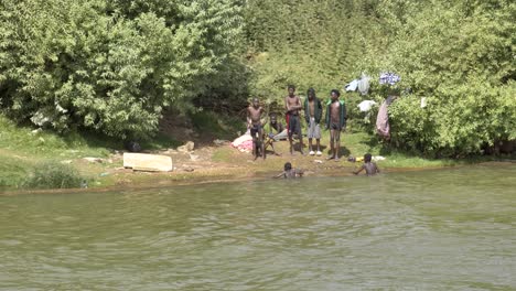 Los-Niños-Saltan,-Nadan-Y-Juegan-En-El-Río-Nilo-Y-Saludan-Al-Barco-Que-Pasa