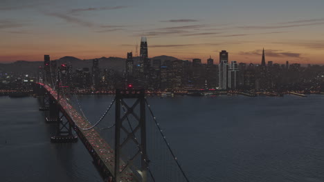 Dozens-of-cars-cross-a-long-bridge-going-in-and-out-of-a-city-along-the-water