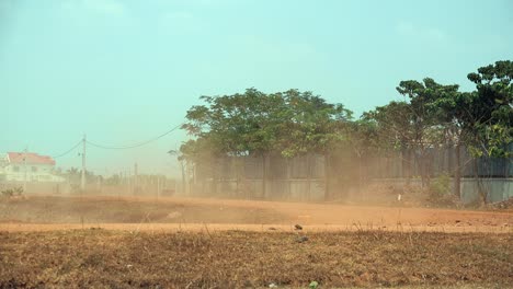 White-Car-Driving-Through-the-Field-Leaving-a-Trail-of-Dust-Behind