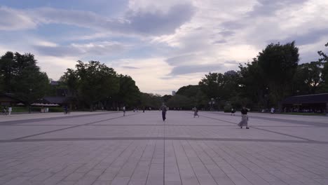 Amplia-Vista-Abierta-De-La-Plaza-Del-Parque-Ueno-Al-Atardecer-Nublado-Con-Gente-Caminando