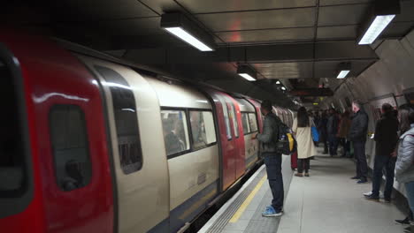 Londoner-U-Bahn,-Zug-Kommt-An-Der-U-Bahn-Station-An,-Menschen,-Die-In-Den-Weihnachtsferien-Reisen,-Zeitlupe,-England,-Vereinigtes-Königreich