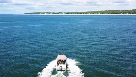 Motorboat-at-Arcachon-Bay-with-people-heading-to-Le-Molleau-shore,-Aerial-orbit-around-shot