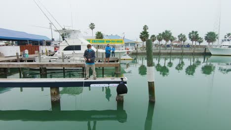 Three-men-fishing-calm-waters-of-harbor-from-docks